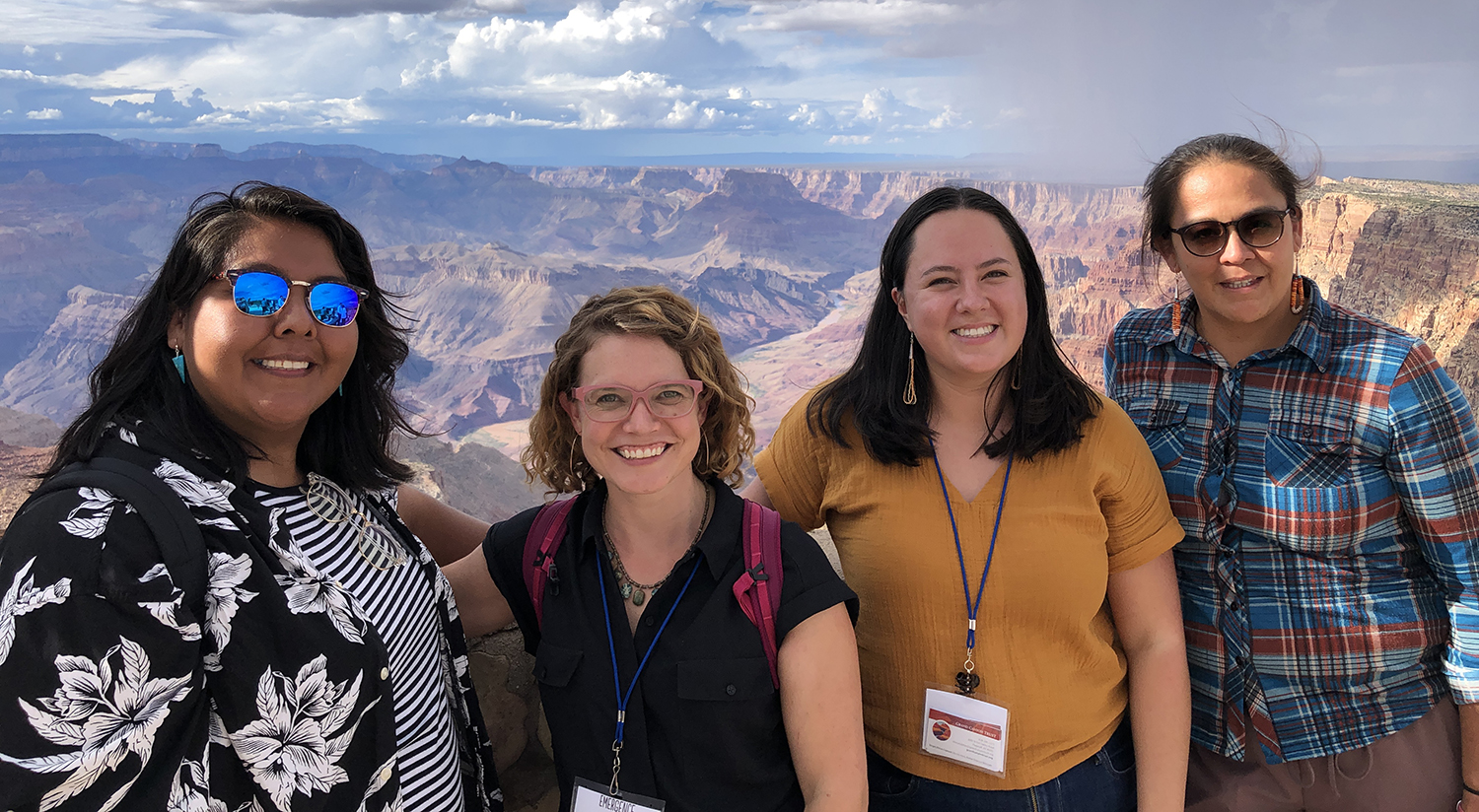 Four staff from the Grand Canyon Trust stand at a scenic overlook at Grand Canyon National Park.
