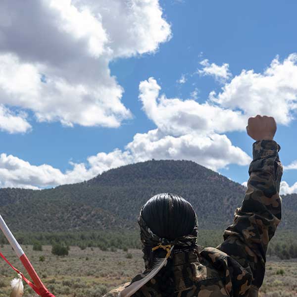 A Havasupai man makes a clenched fist while looking at Red Butte.