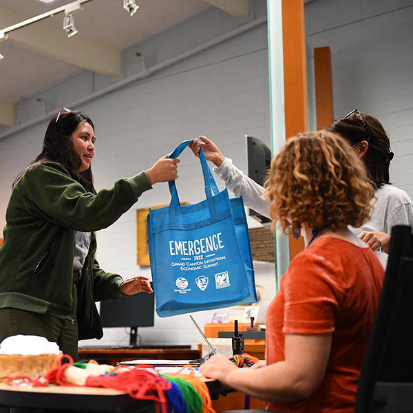 Grand Canyon Trust staff hand out a goody bag to a park ranger at the Emergence intertribal economic summit.