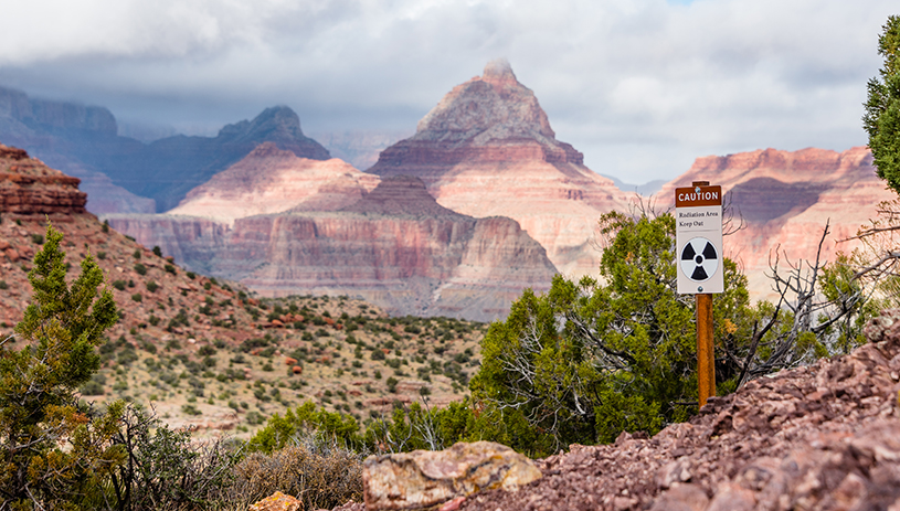 A radiation warning sign stands in front of Grand Canyon