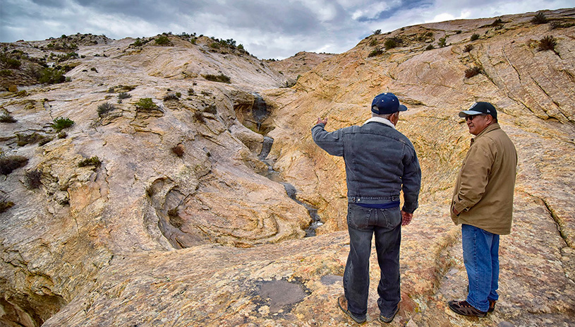 Two men observe the Bears Ears landscape.