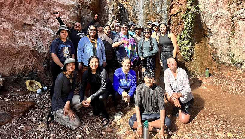 RIISE participants stand near a waterfall