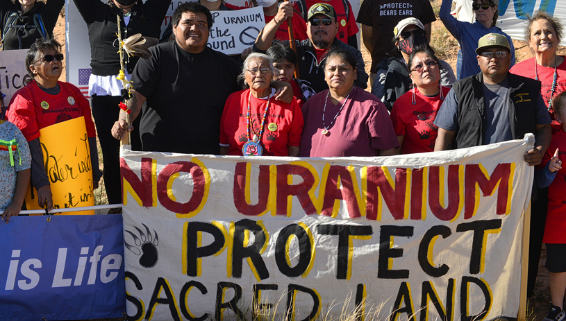 Ute elder Thelma Whiskers (at center with rose necklace) her daughter, Yolanda Badback (in mauve), Ute Mountain Ute Tribal Councilman Conrad Jacket (directly behind, in baseball cap) and community members and leaders protest in front of the mill turnoff. TIM PETERSON