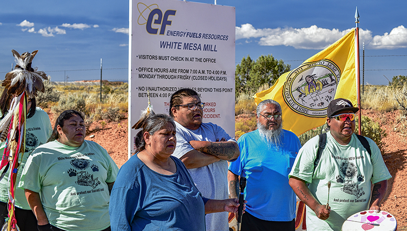 Yolanda Badback, Michael Badback, and other community members sing near the gates of the White Mesa Mill. TIM PETERSON