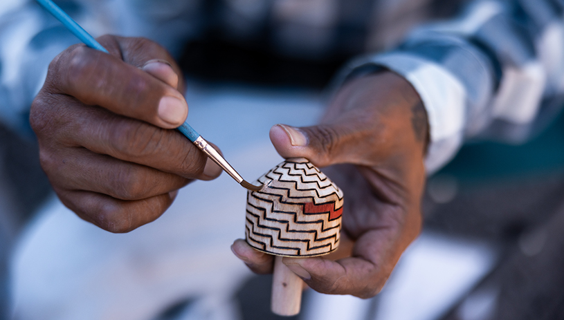 Whimsical hard-carved and hand-painted tops by Gregory Hill. Photo by Raymond Chee