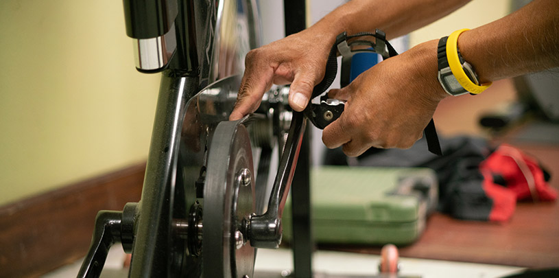 Sam Shingoitewa, of Sunbear Fitness and Repair Services, works on a treadmill