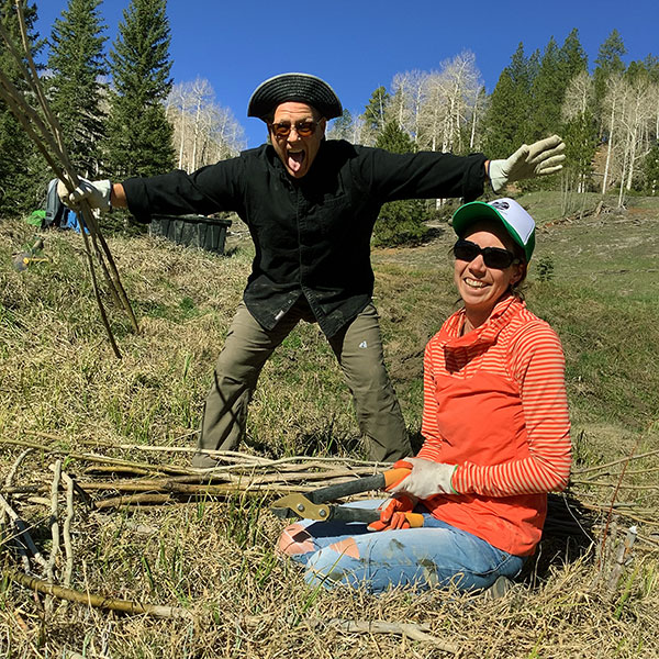 Two volunteers plant willows in Utah on a volunteer trip