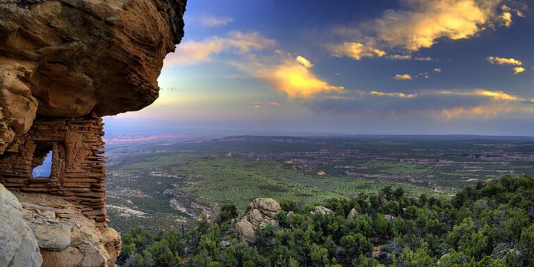 Rock structure built into cliffside with green valley stretching below, Bears Ears National Monument
