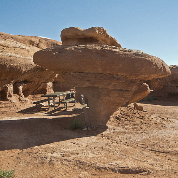 A picnic table next to a rock outcrop in Hamburger Rock Campground