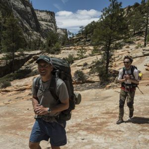 Two hikers on the East Rim Trail surrounded by sandstone monoliths
