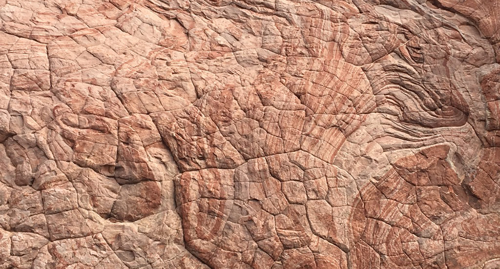A close-up of swirly sandstone with reds, oranges, and creams in Big Horn Canyon
