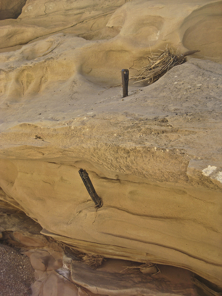 Metal pieces embedded in sandstone are remnants of mining history in the region