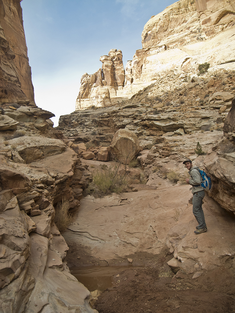 A hiker stands on a slickrock slap in Ding Canyon