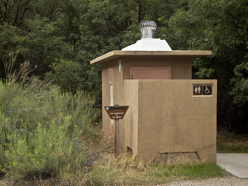 Cement building with a vault toilet at Drinks Canyon Campground