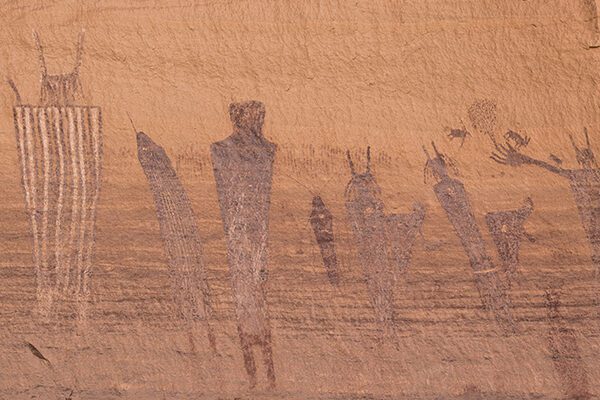 A pictograph panel showing large figures in a line