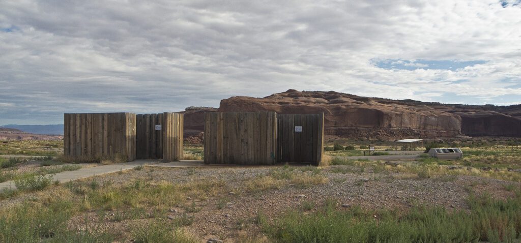 Two wooden vault toilets at Lone Mesa Campground
