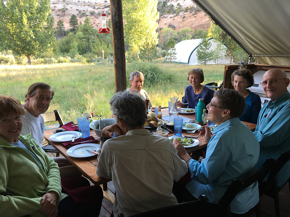 A group of Trust donors eats breakfast beneath a white canvas tent.