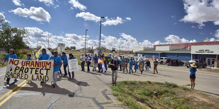 White Mesa Community members leave the the community center following a banner that says No uranium protect sacred land