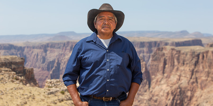 Franklin Martin in a blue collared shirt and cowboy hat on the rim overlooking the Little Colorado River