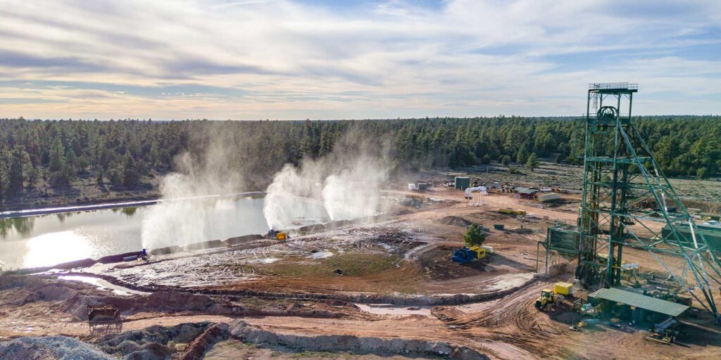 Water cannons spray water from Canyon Mine's pond into the forest.