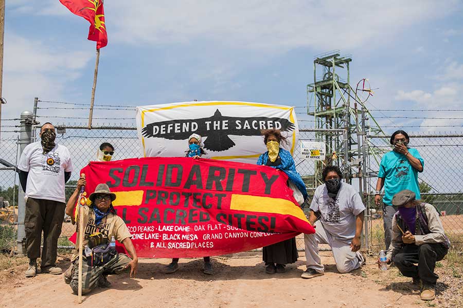 A group of Havasupai ativists hold a "solidarity" sign at the Canyon uranium mine