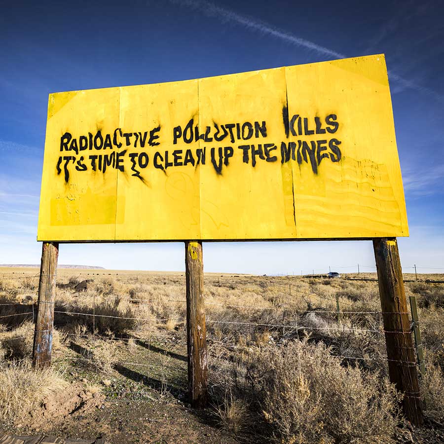 A bright yellow sign says "Radiation pollution kills"