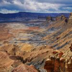 Yellow rock mesa with folds of grey and yellow rock along its sides in Grand Staircase-Escalante National Monument
