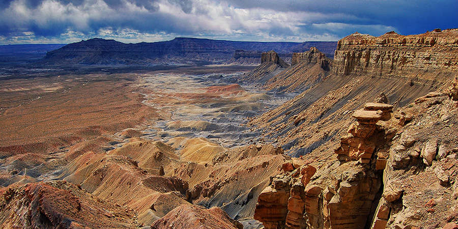 Yellow rock mesa with folds of grey and yellow rock along its sides in Grand Staircase-Escalante National Monument